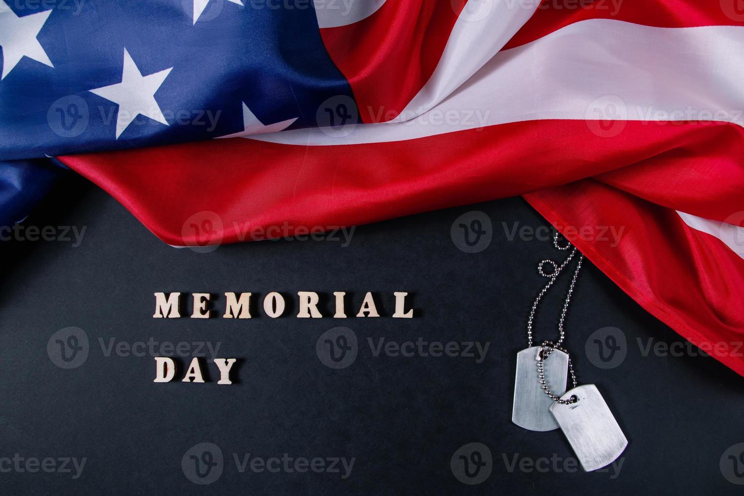 concepto del día conmemorativo. bandera americana y etiquetas de perro militares sobre fondo negro. recordar y honrar. foto