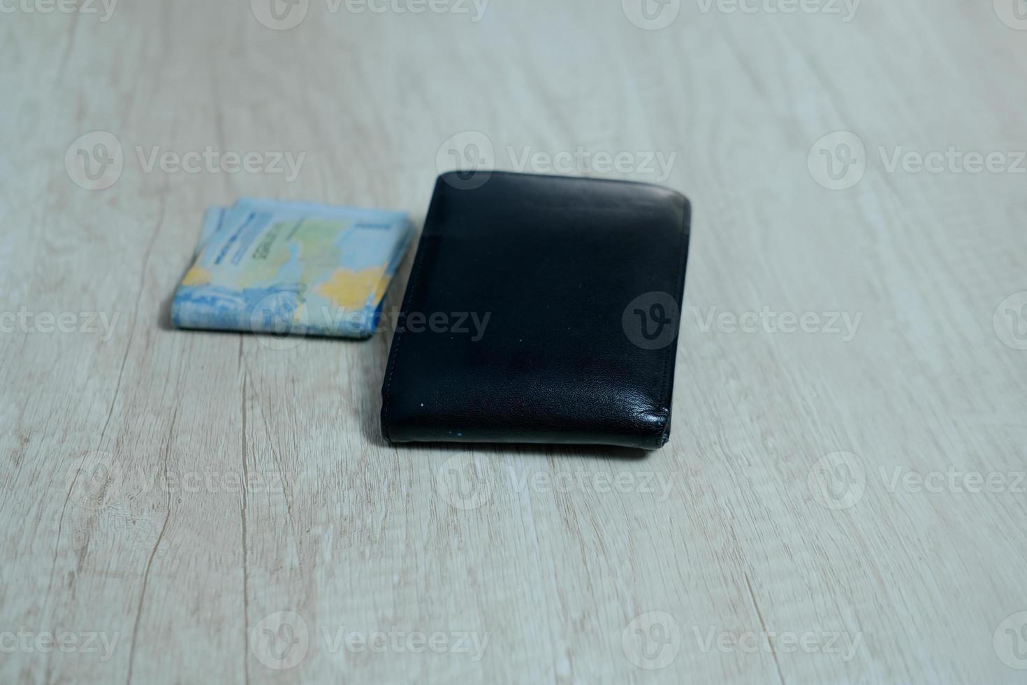 Black leather wallet with fifty thousand rupiah on the table photo