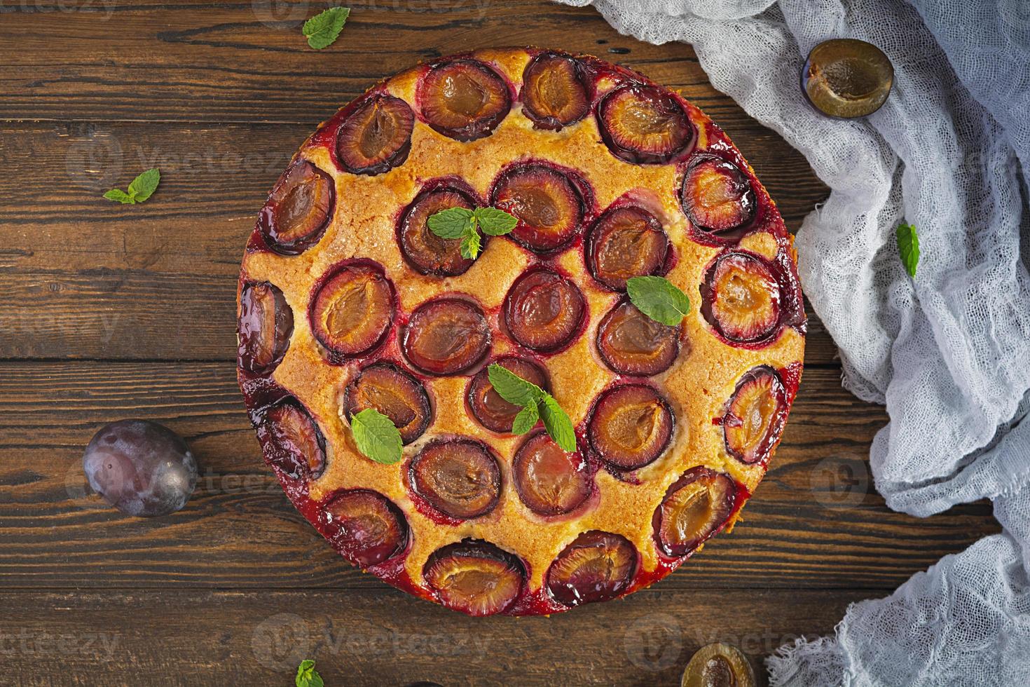 Delicious homemade plum pie on rustic background. Top view photo