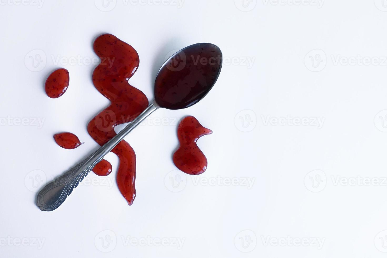 the drops of homemade sauce and a spoon on a white background photo