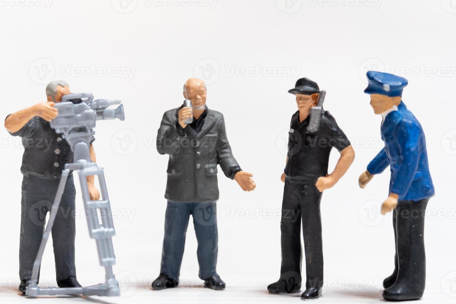 Miniature news reporter with microphone and cameraman interviewing police officers photo