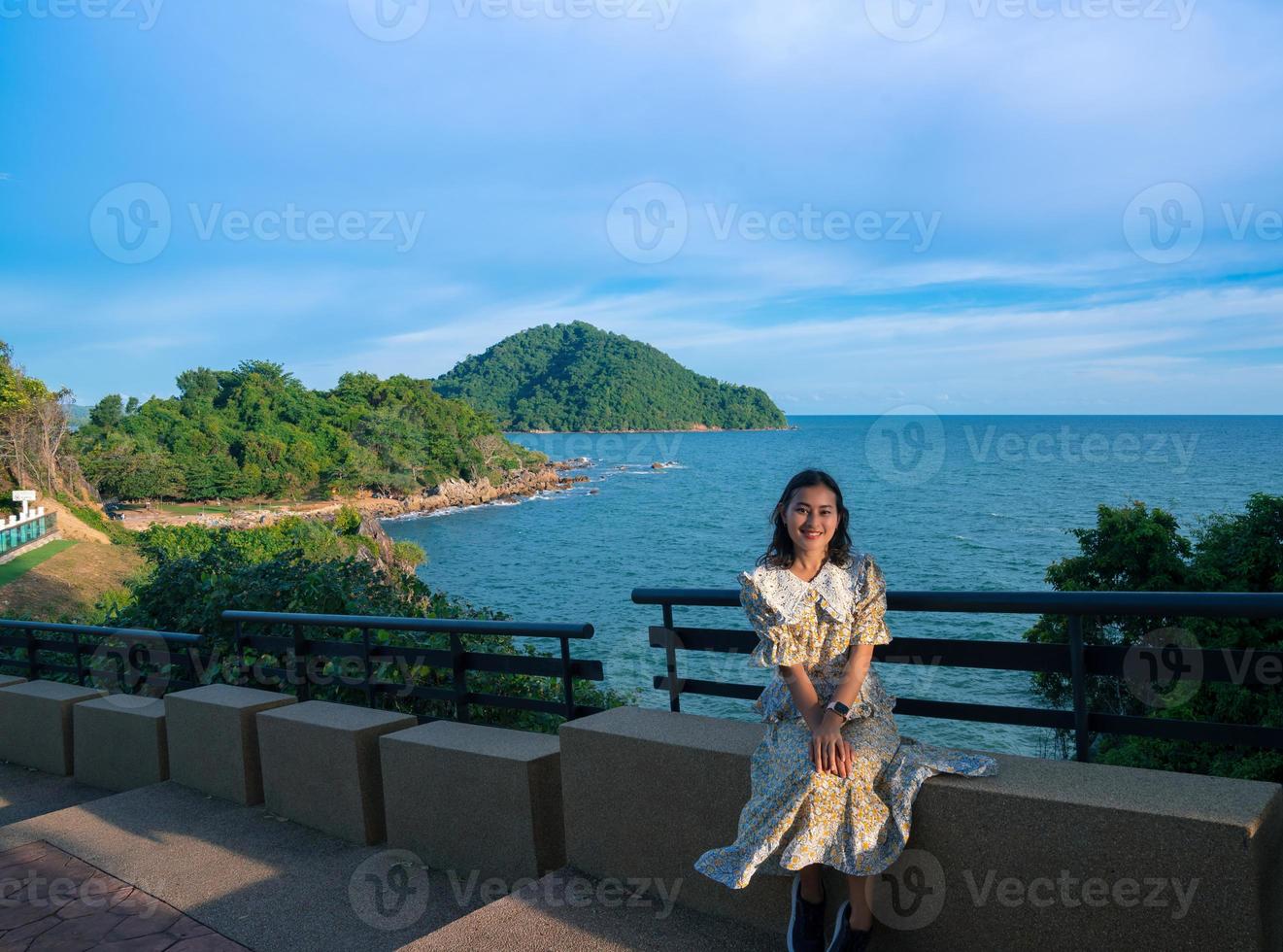 Asian woman tourist sit at seat beside walkway on Noen Nang Phaya viewpoint with blue sea and mountain view photo