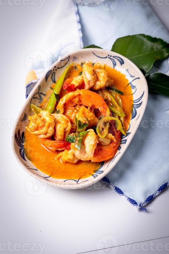 Stir fried shrimp with curry paste in a white plate. photo