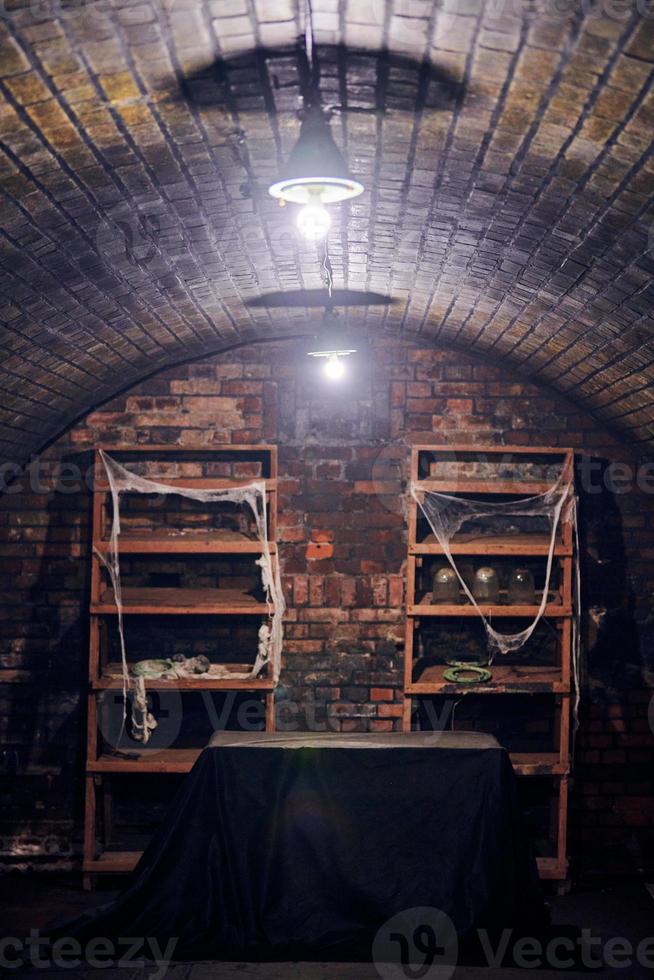 Old abandoned basement with shelving covered spider web, gloomy cold basement with creepy atmosphere photo