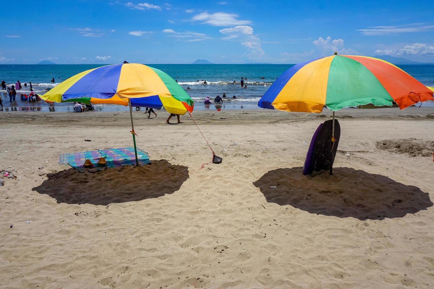 Colorful umbrella on the sand beach under blue skies. Summer vacation travel. Tropical holiday travel. Free photo