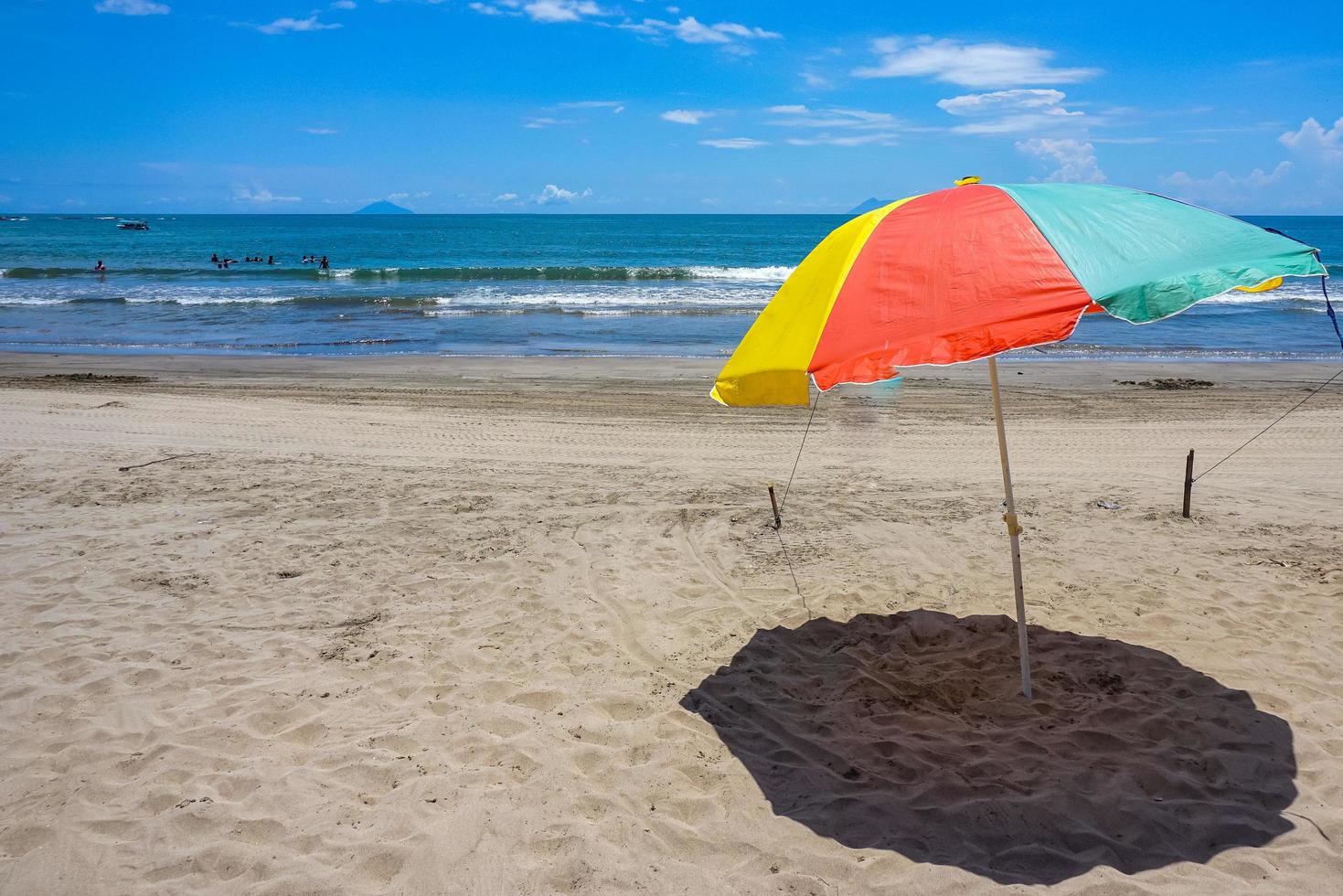 Colorful umbrella on the sand beach under blue skies. Summer vacation travel. Tropical holiday travel. Free photo