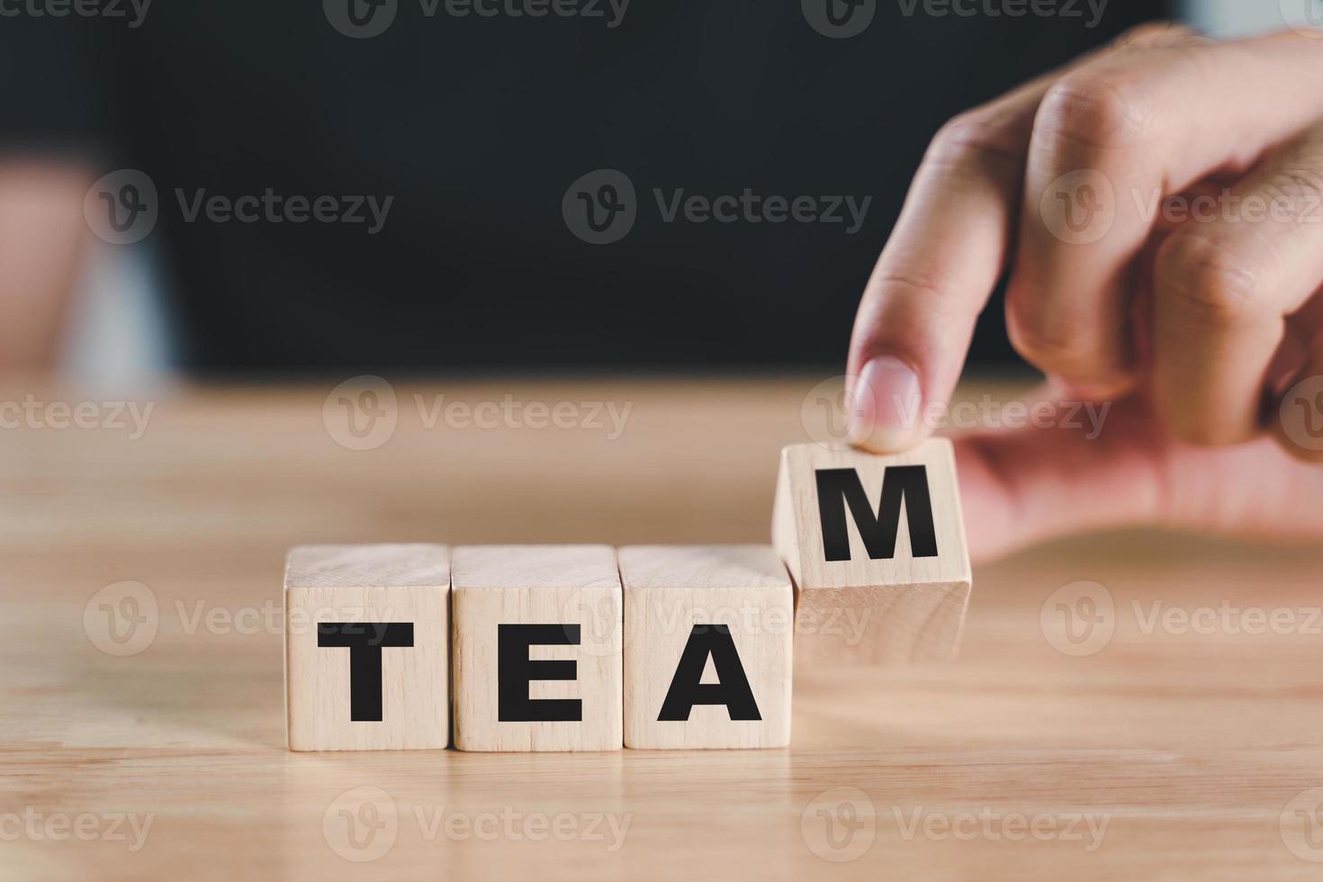 mano de hombre poniendo bloque de cubo de madera con texto de equipo en mesa de madera. colaboración y liderazgo, trabajo en equipo para intercambiar ideas juntos, conceptos de negocios. foto