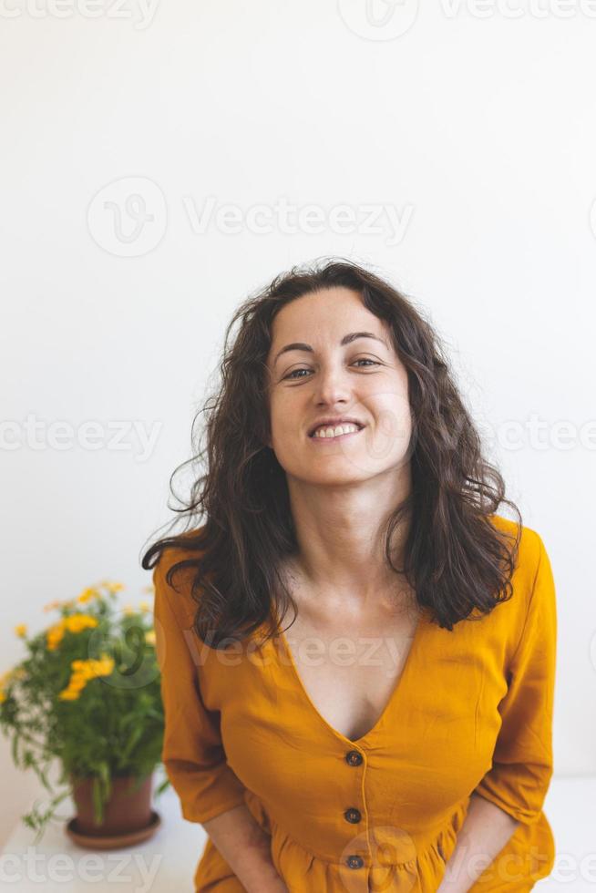 A woman and a pot with a flowering plant photo