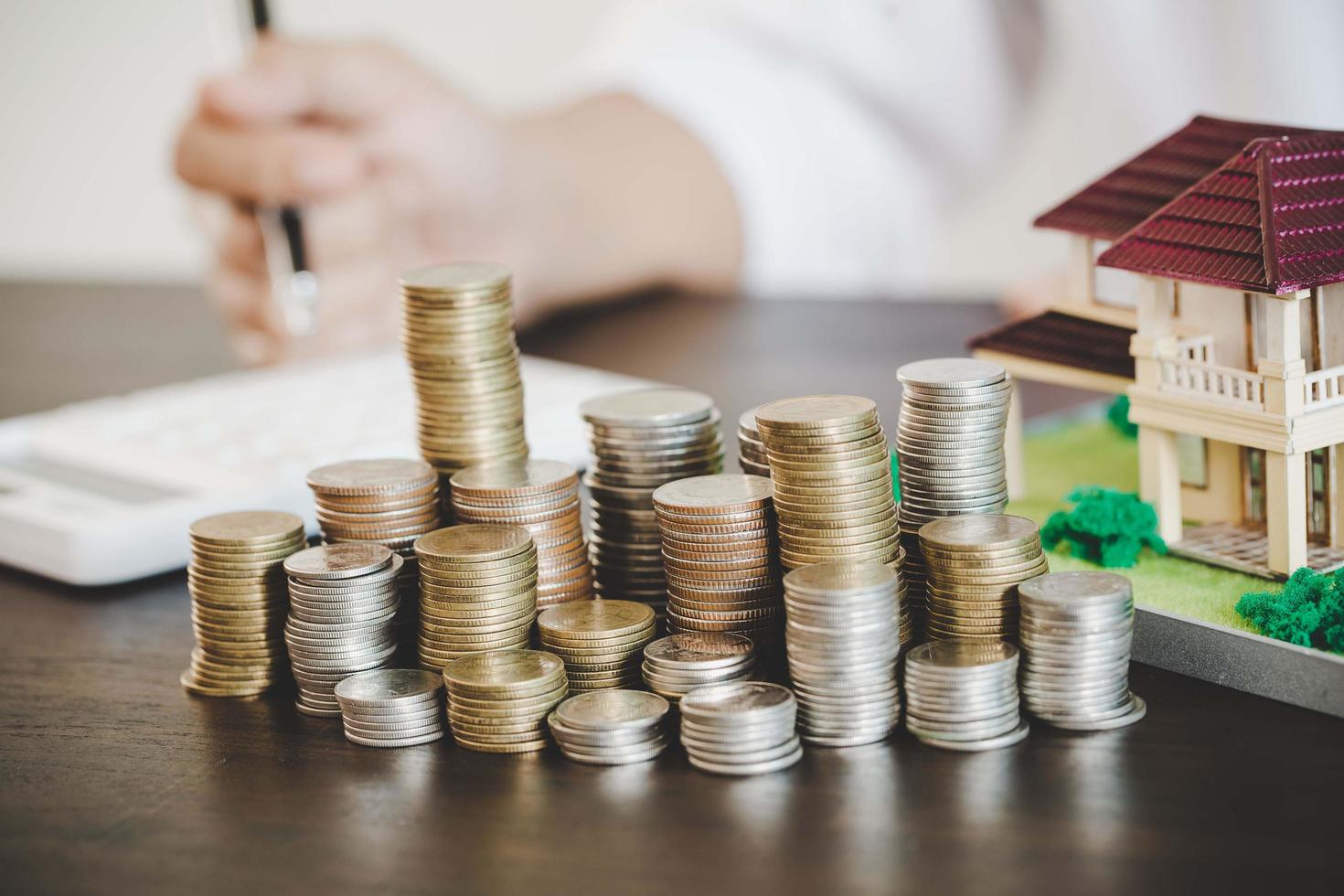 Coins stacking with house model photo