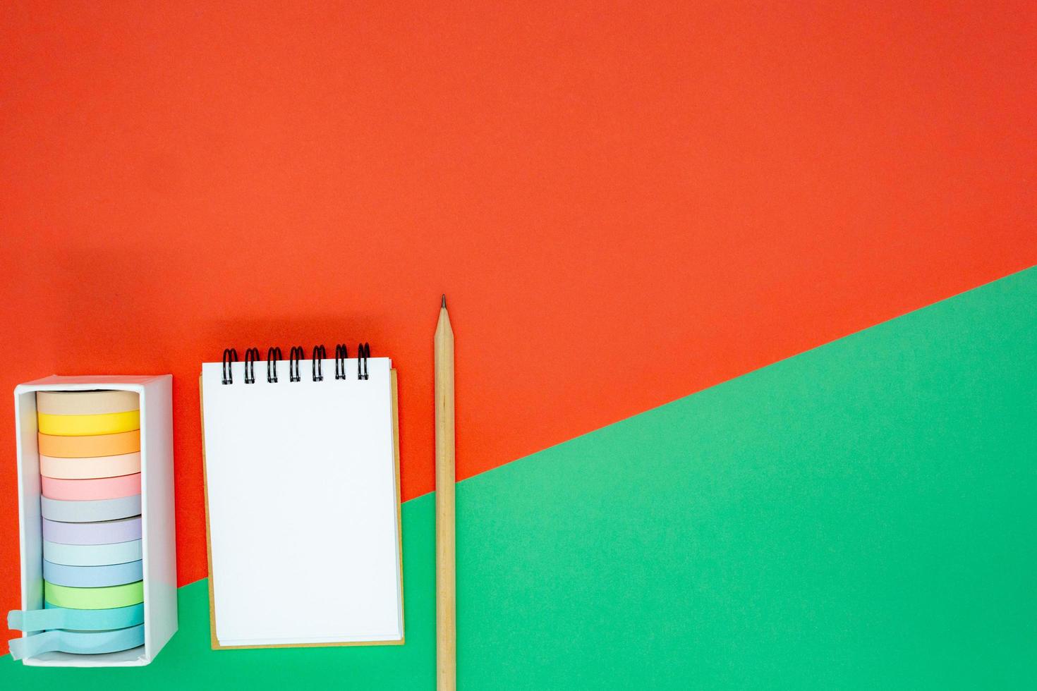concepto de navidad o vacaciones. mini bloc de notas en espiral blanco, lápiz de madera y cinta de colores. foto