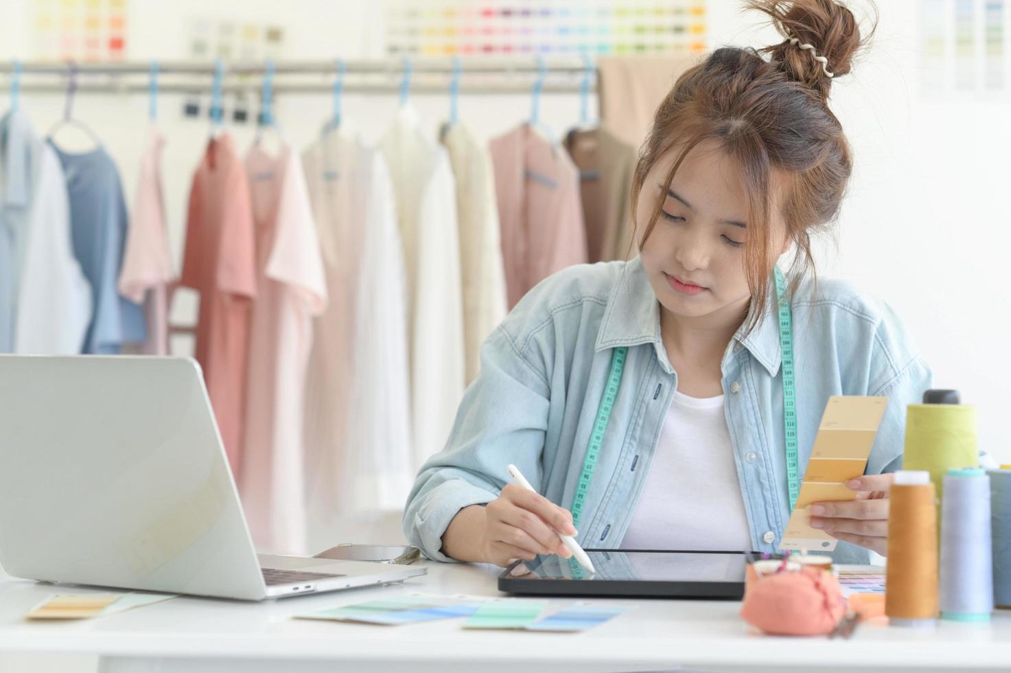 ropa de diseñador de mujer joven, espacio de trabajo de diseñador de ropa, accesorios de diseño de ropa. foto