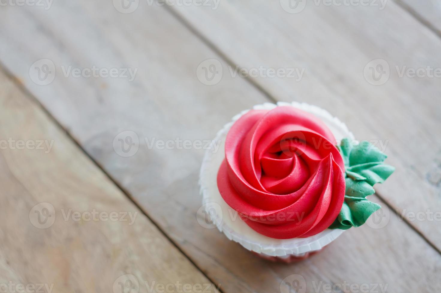 red rose cupcake on wooden table photo