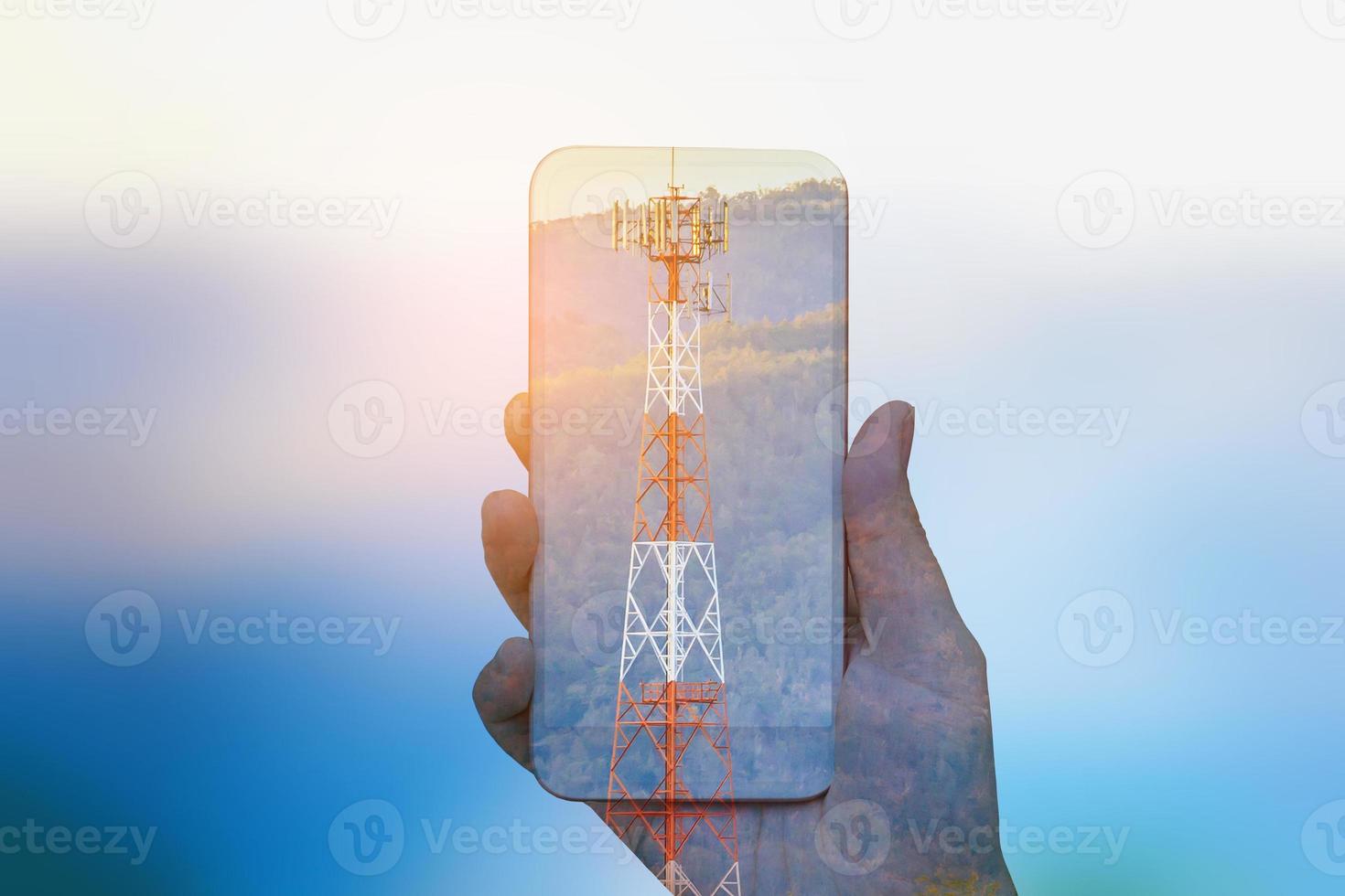 hand hold mobile smartphone double exposure with telecom tower photo
