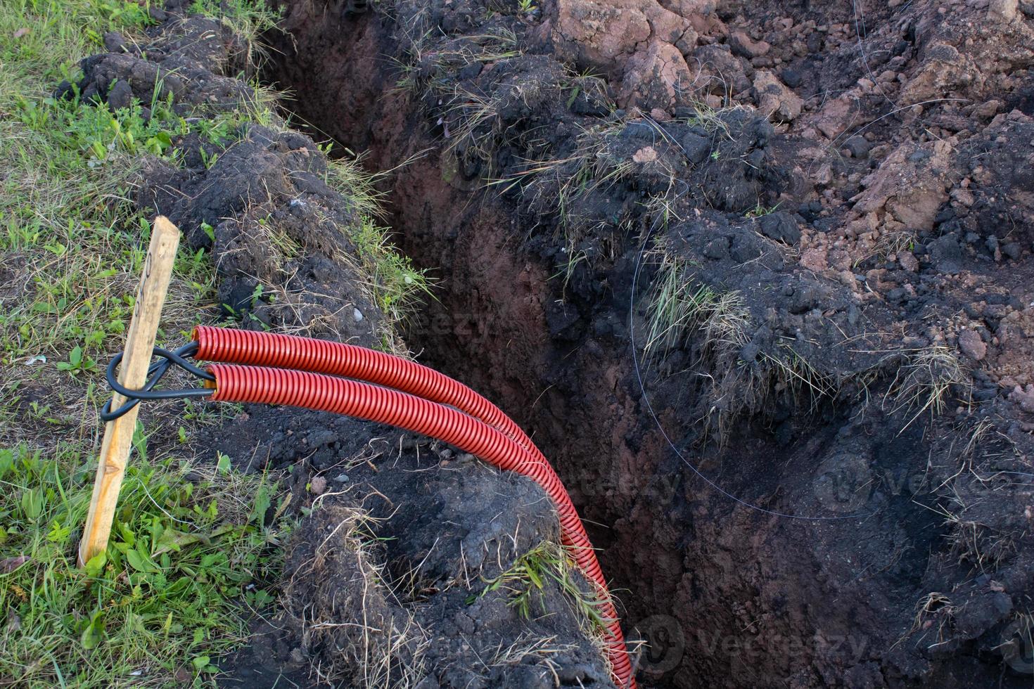 Laying communications in the ground. Red electric cable. photo