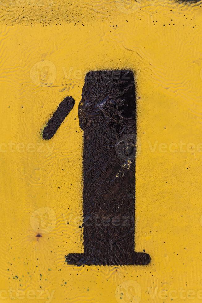 black number stencil painted on yellow background, number 1, number one