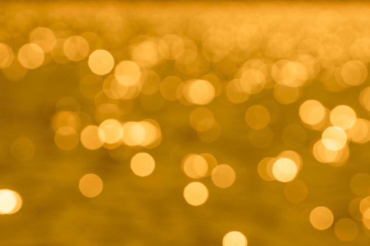 Bokeh light from reflection of golden water surface in the evening sunset photo