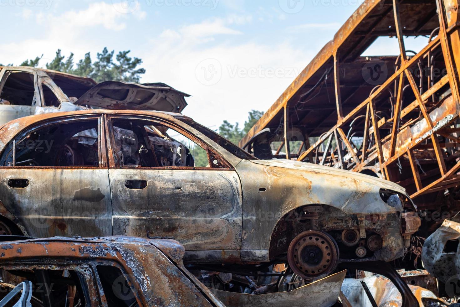 The car burned down completely, even the tires burned out. Burnt out car crash after fire. The bomb shell of the terrorist attack blew up civilians. Disaster zone. Abandoned car on the road. photo