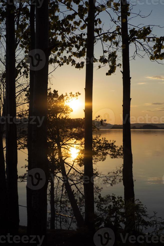 sunset on the river through the trees photo