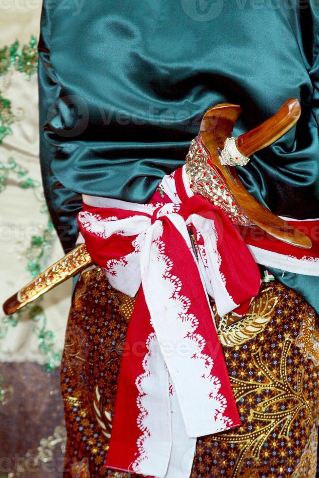Beskap is an Indonesian traditional dress for the Javanese people. Keris is a traditional Javanese weapon that is usually tucked in a beskap. Usually used for traditional events such as weddings. photo