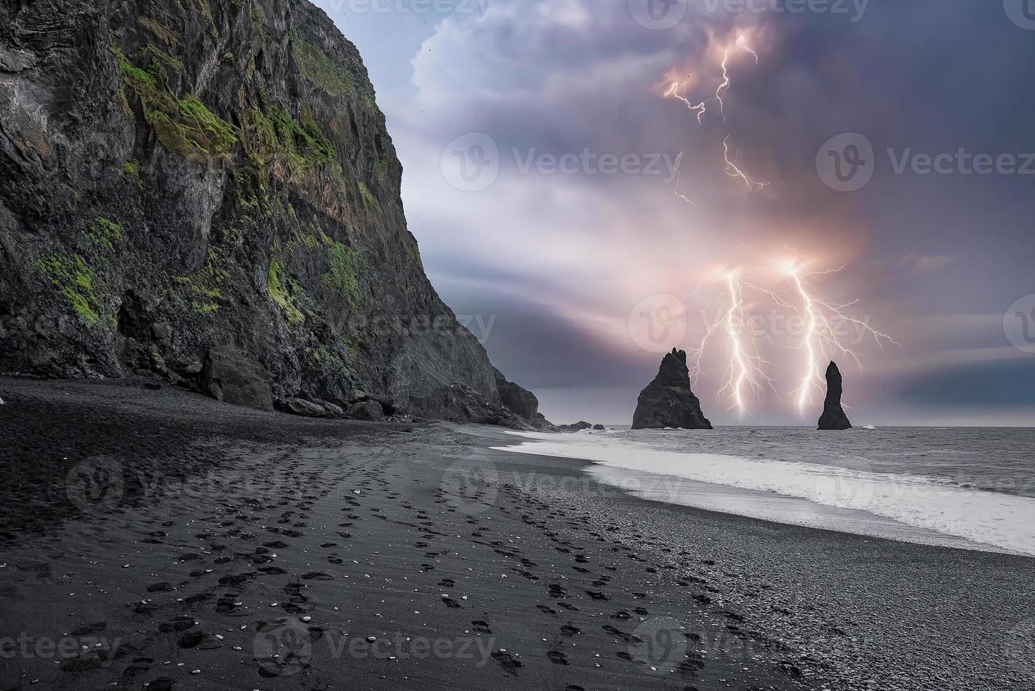 Beautiful view of lightning at black sand Reynisfjara Beach during stormy night photo