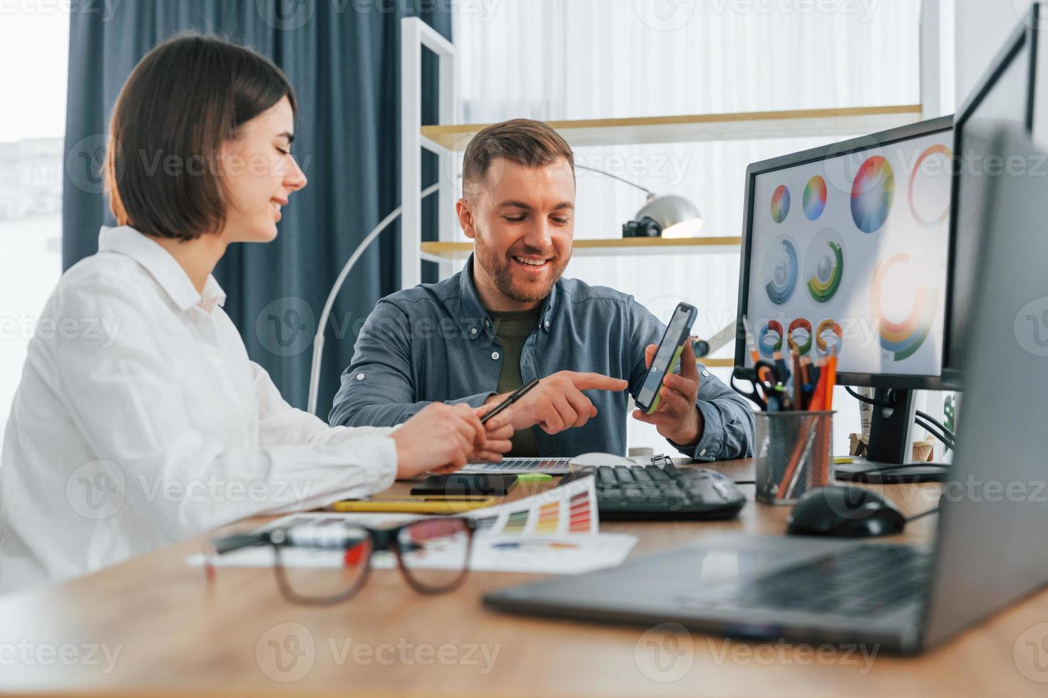 hablando y creando contenido. dos diseñadores trabajando juntos en la oficina foto