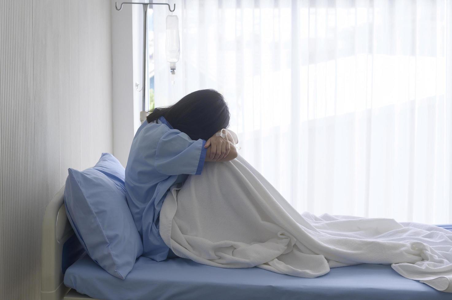 A despondent Asian woman patient. Following the doctor's declaration that the cancer was nearing the end of its course. photo