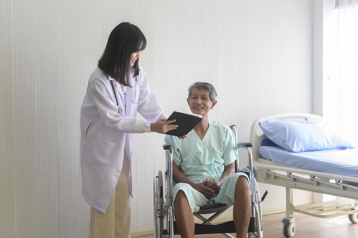 médico que ayuda a un paciente mayor a trasladarse a sillas de ruedas en el hospital, la atención médica y el concepto médico foto