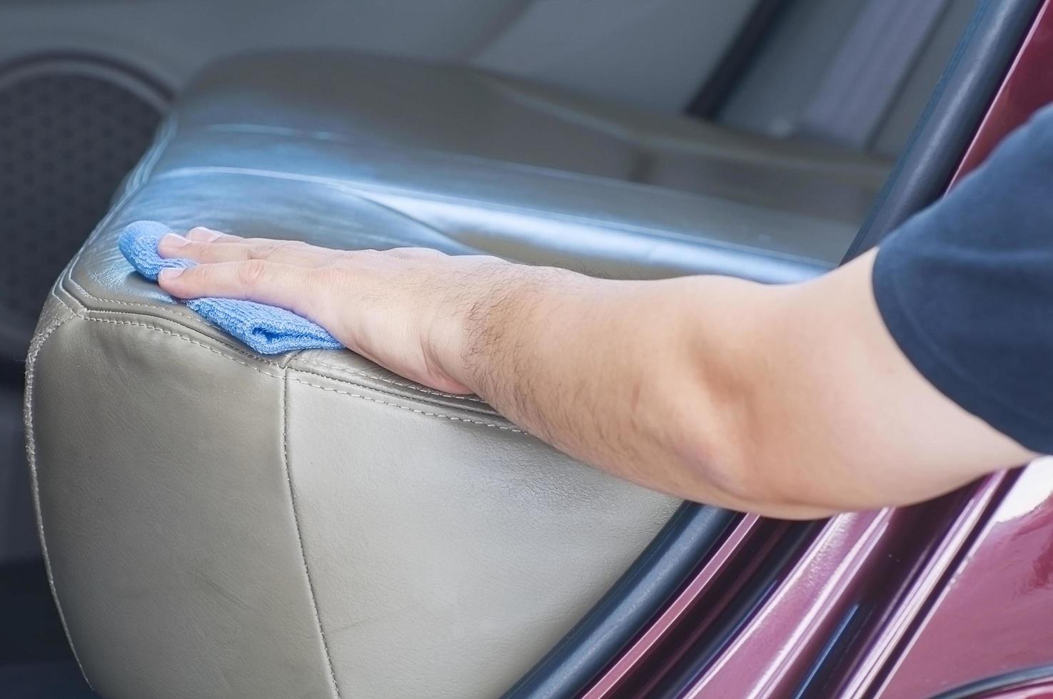 Man's hand is cleaning and waxing the car photo