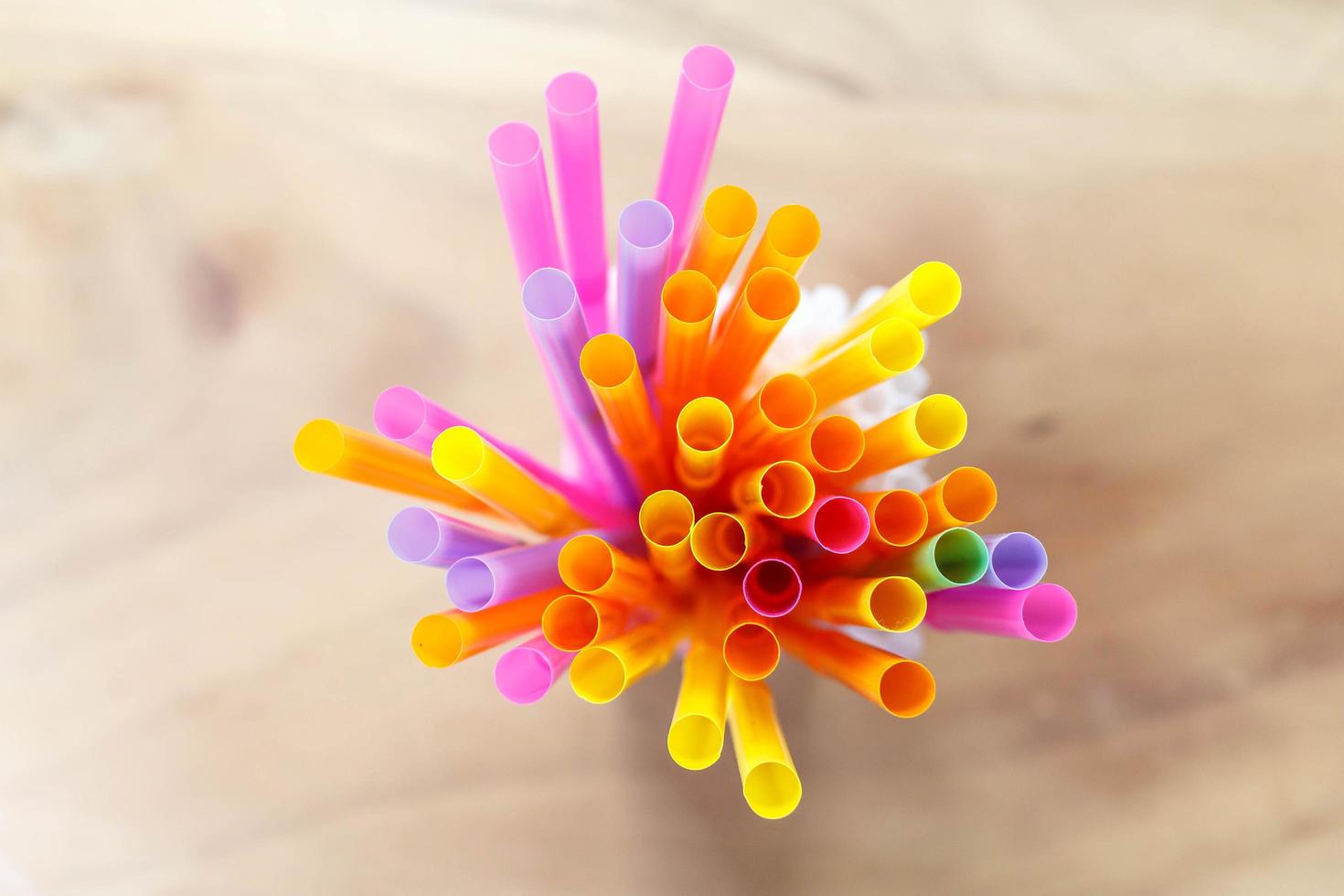 multi colored drinking straws on wooden table photo