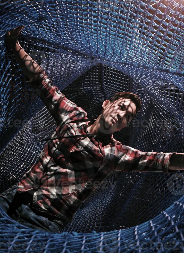Entangled - a man spreads his arm in a net photo