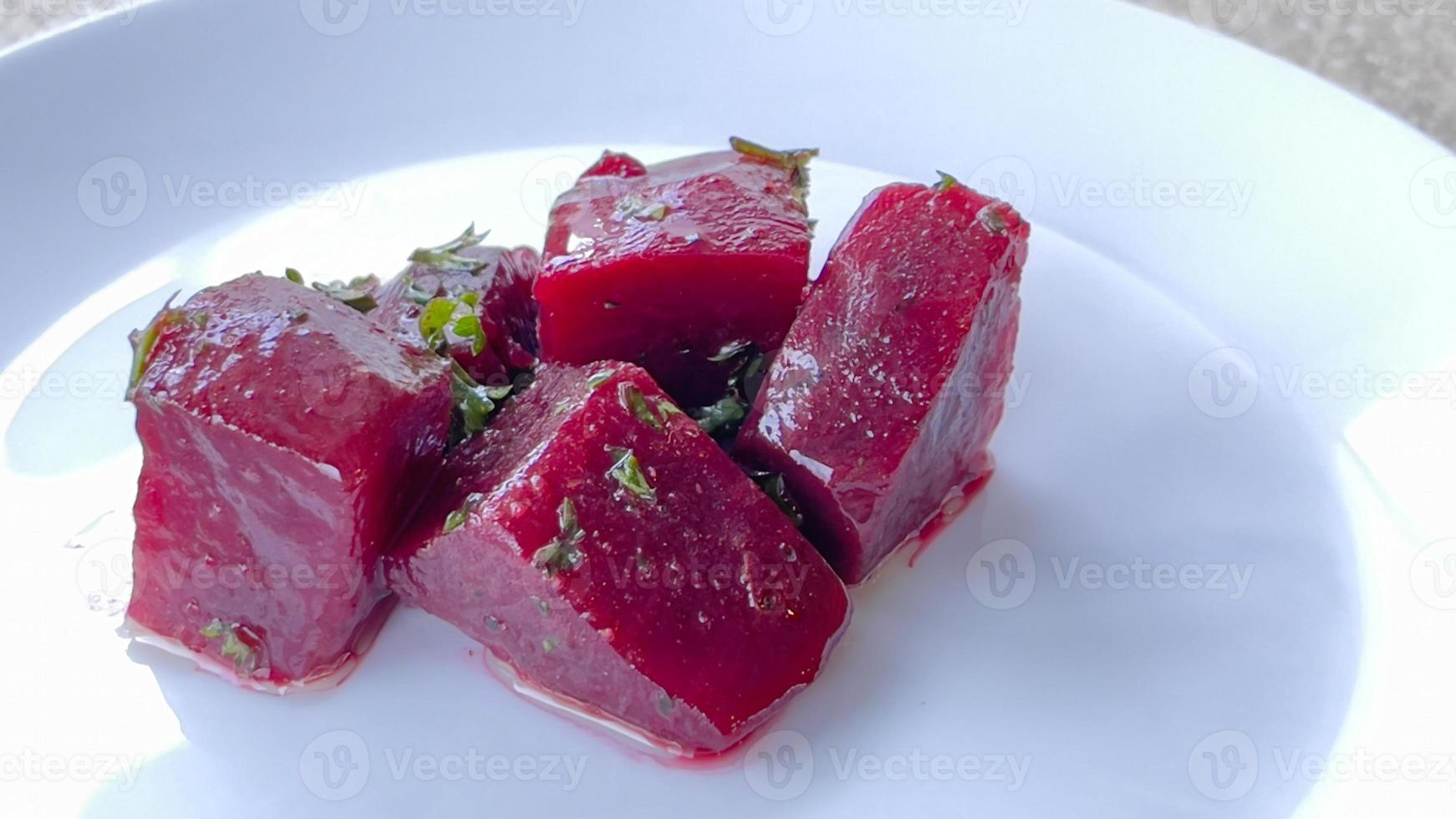 A piece of beetroots sliced with salad on white dish. photo