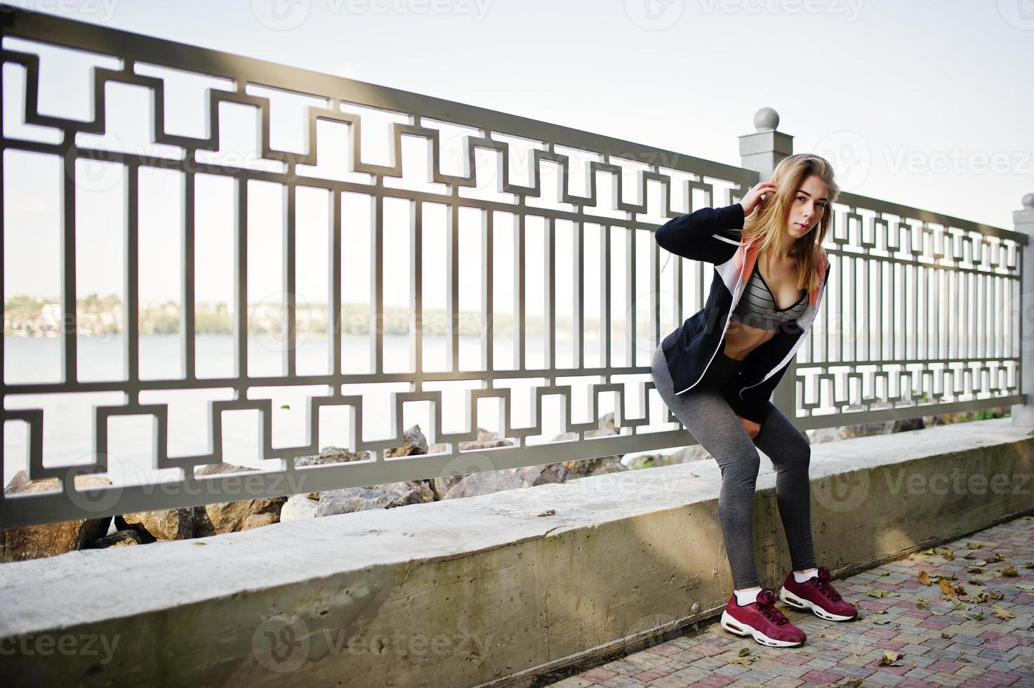 Young girl has the training and doing exercise outdoors. Sport, fitness, street workout concept. photo