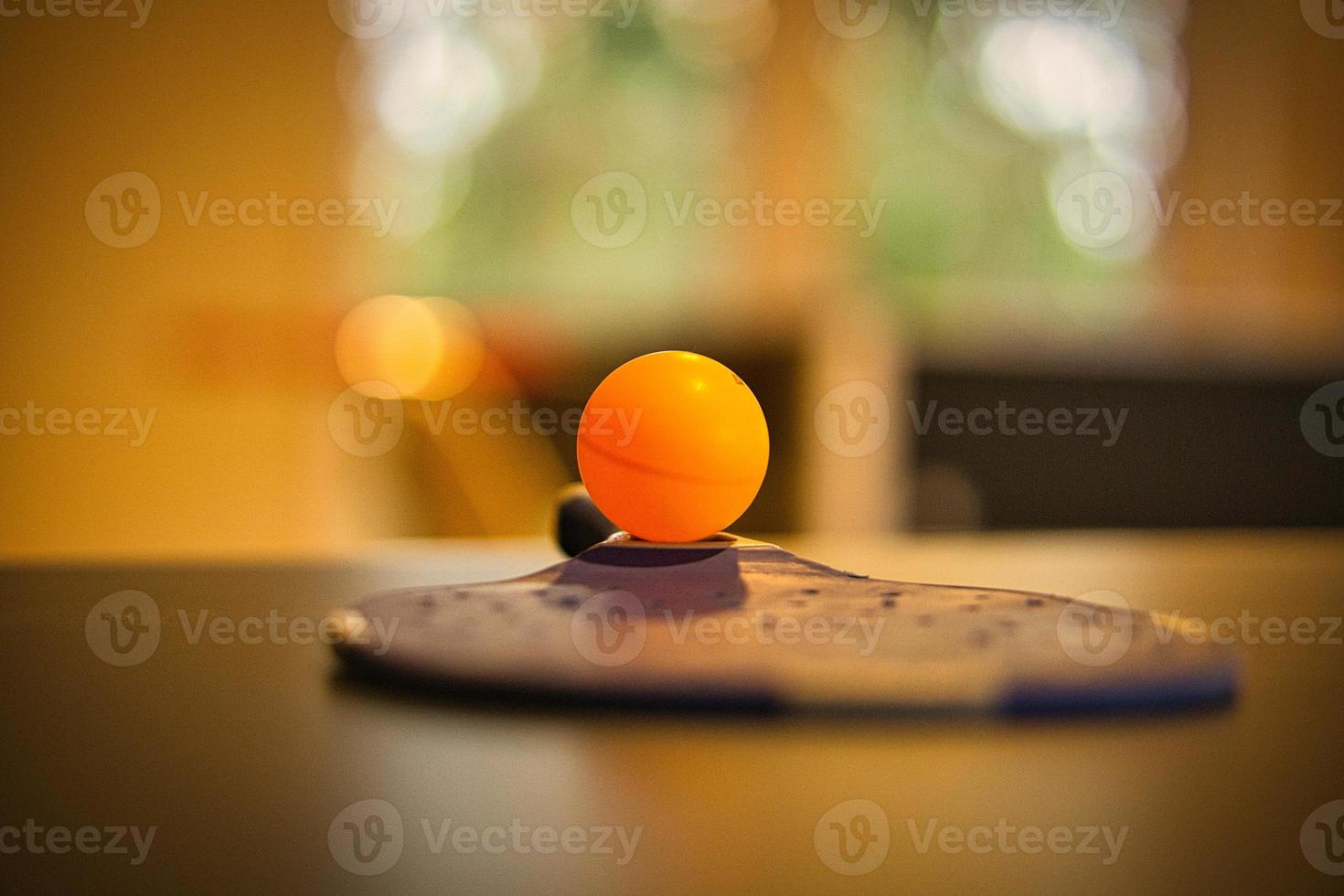 Table tennis bat with ball on a table tennis table. Pause before the game. photo