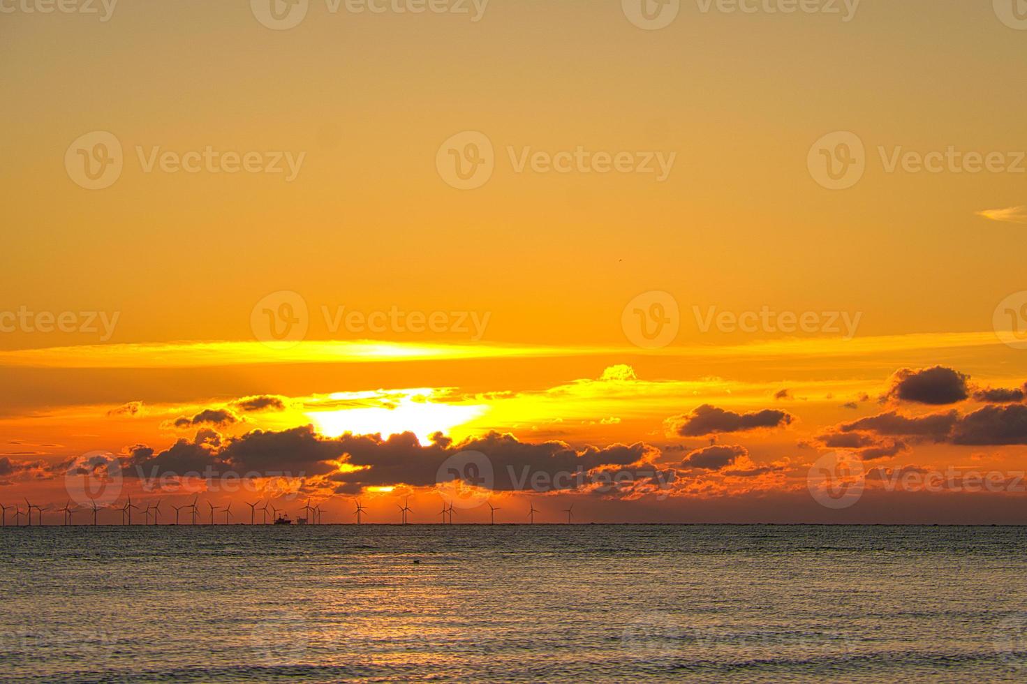 Sunset by the sea in colorful play of light in the clouds. Blavand Denmark. photo