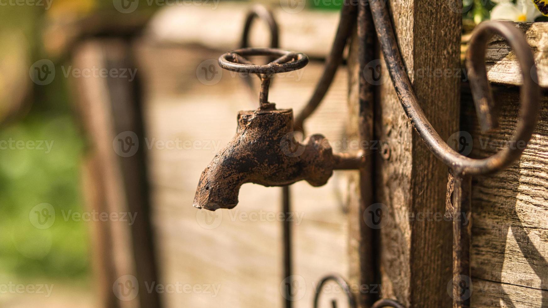 Faucet as deco in old with rust on a wooden board. photo