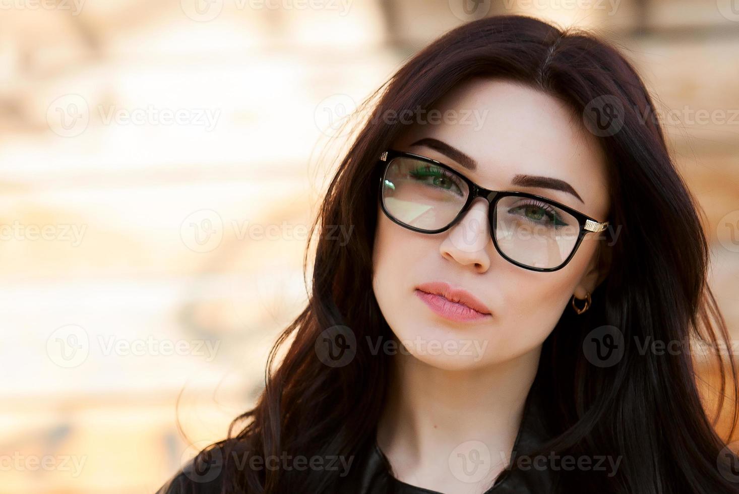 portrait of a beautiful hipster girl in glasses. Beautiful eyes, beautiful smile, vision, perfect skin Portrait of a beautiful girl with glasses, eyes closed. photo