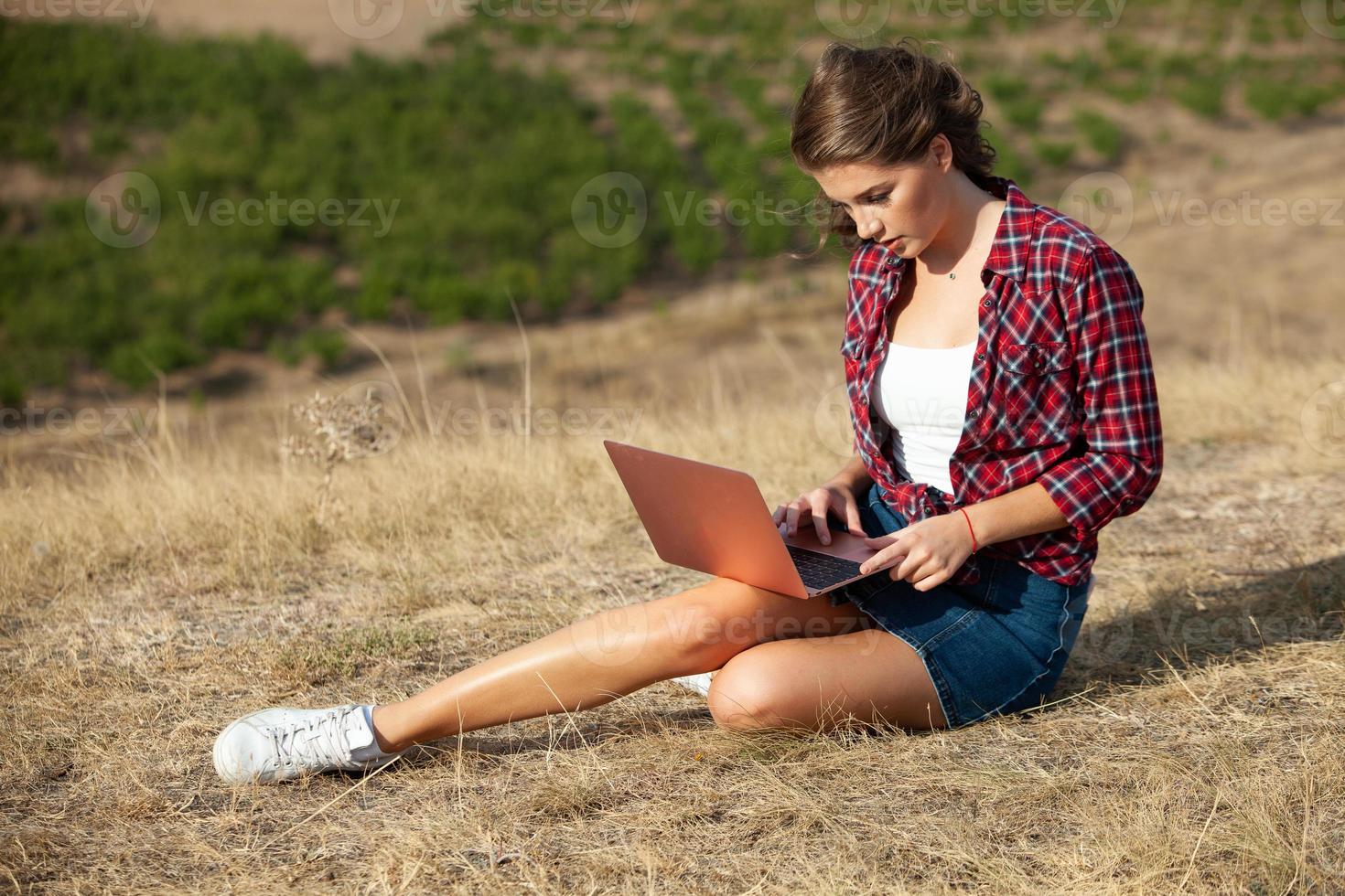 Office outdoors. Beautiful girl works on a laptop in the open air. woman freelancer. Freelance worker concept. photo