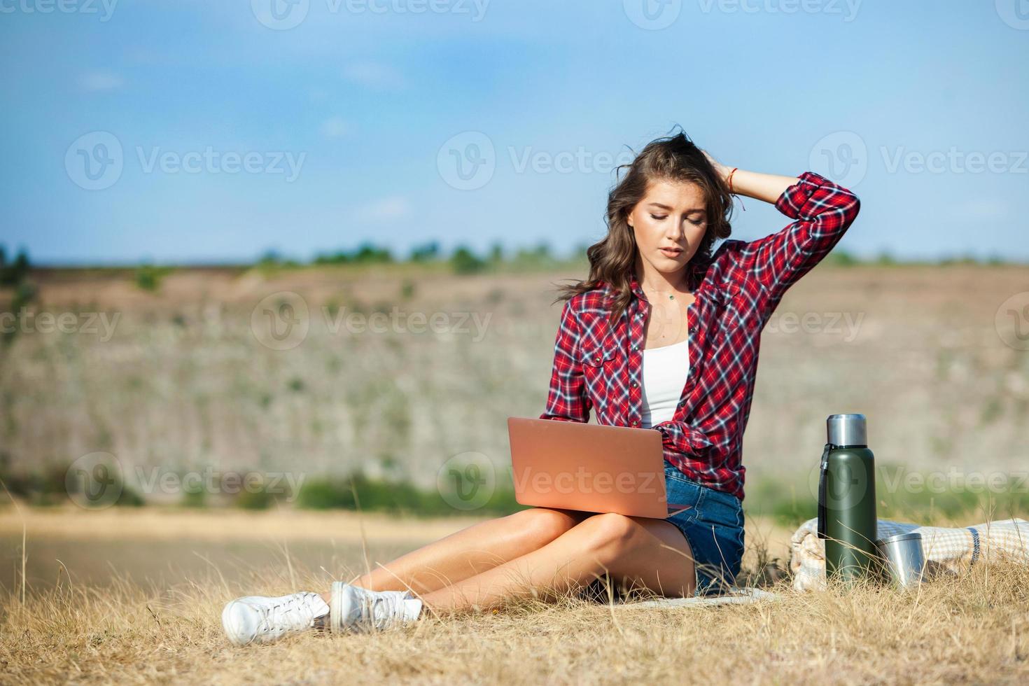 Office outdoors. Beautiful girl works on a laptop in the open air. woman freelancer. Freelance worker concept. photo