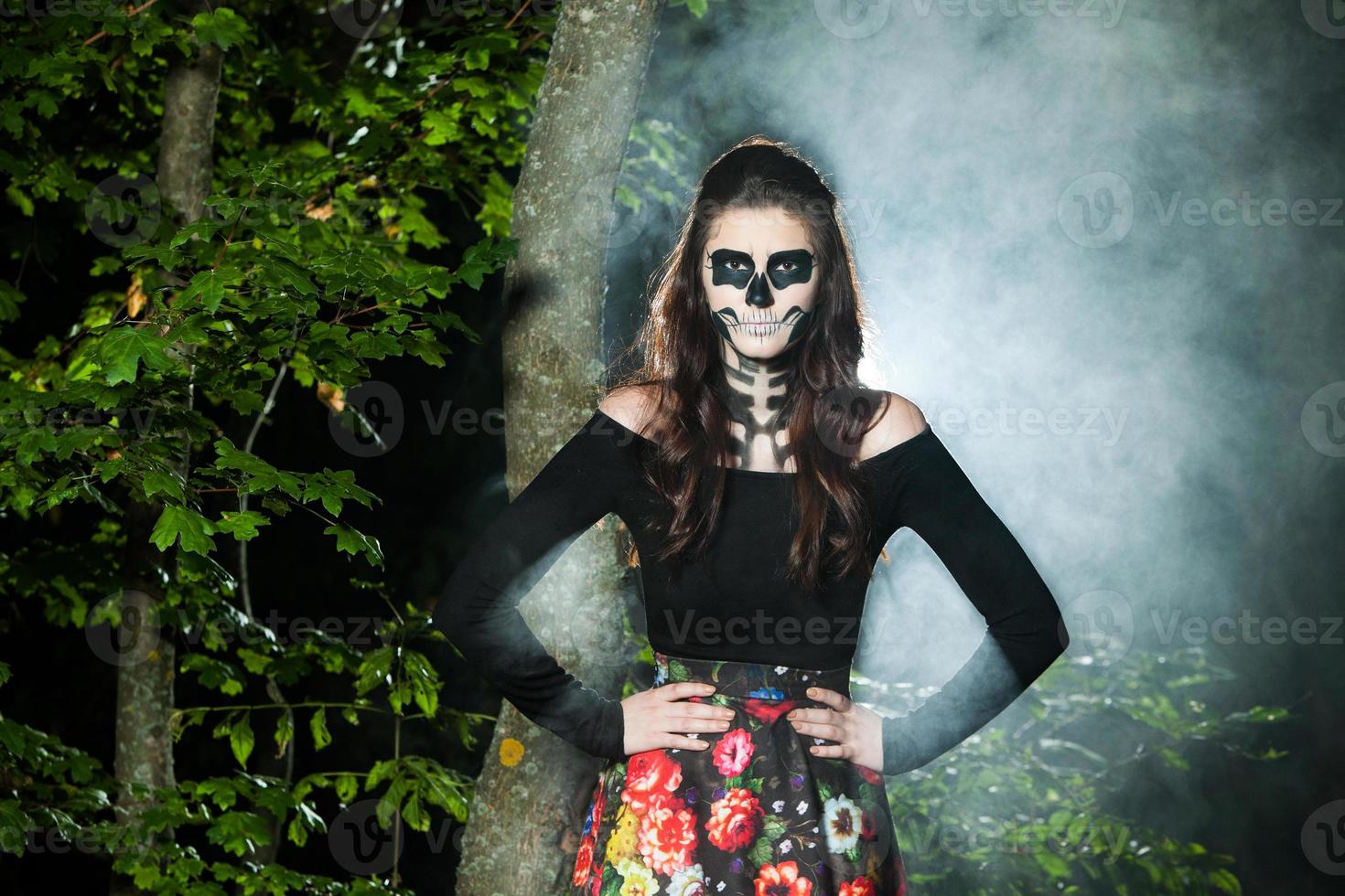 Halloween Vampire Woman portrait over scary night background. Vampire makeup Fashion Art design. Model girl in Halloween costume and make up. photo