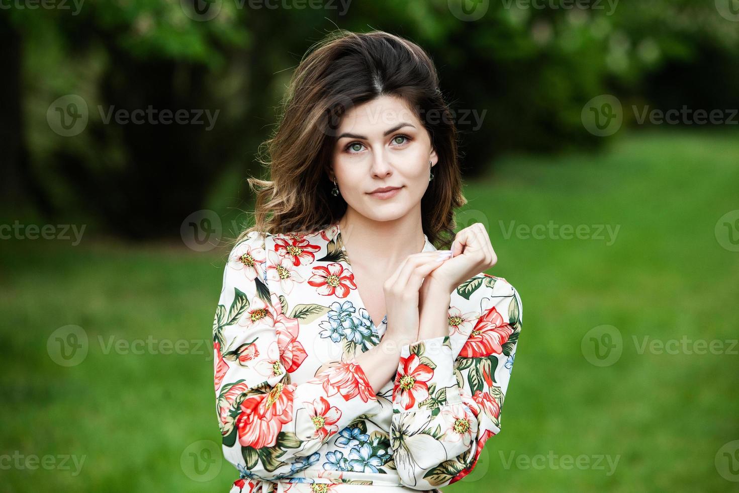 Woman's portrait with a hair moving in the wind.  portrait of young beautiful Russian brunette girl at summer green park. European white woman in dress. photo