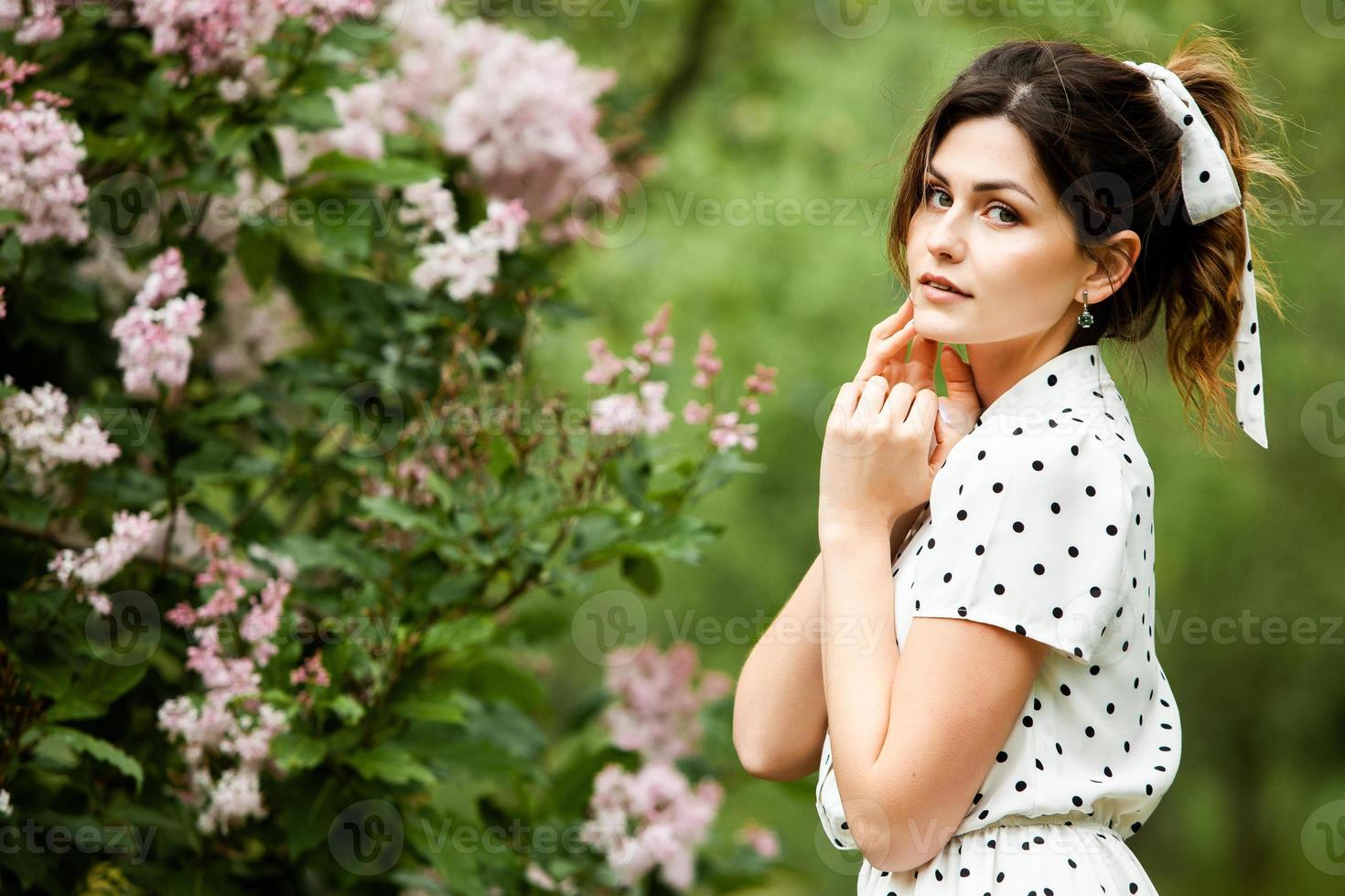 Woman's portrait with a hair moving in the wind.  portrait of young beautiful Russian brunette girl at summer green park. European white woman in dress. photo