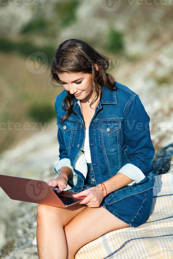 Office outdoors. Beautiful girl works on a laptop in the open air. woman freelancer. Freelance worker concept. photo