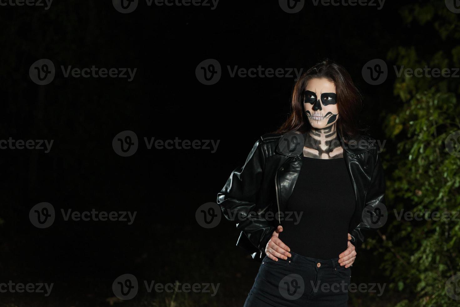 Halloween Vampire Woman portrait over scary night background. Vampire makeup Fashion Art design. Model girl in Halloween costume and make up. photo