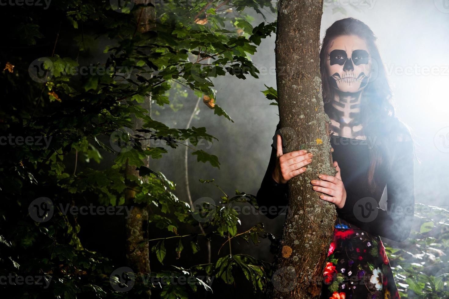 Halloween Vampire Woman portrait over scary night background. Vampire makeup Fashion Art design. Model girl in Halloween costume and make up. photo