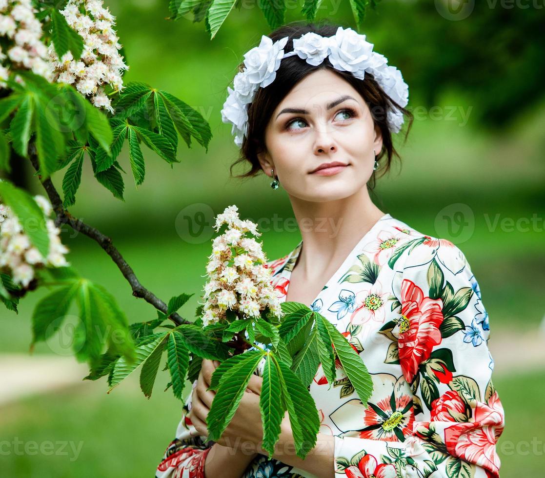 retrato de mujer con un cabello moviéndose en el viento. retrato de joven hermosa chica morena rusa en el parque verde de verano. mujer blanca europea vestida. foto