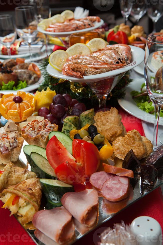 hermosa mesa festiva servida para la cena de celebración de bodas en casa o en el interior del restaurante. mesa llena de comida en un restaurante. mesa redonda completa. foto