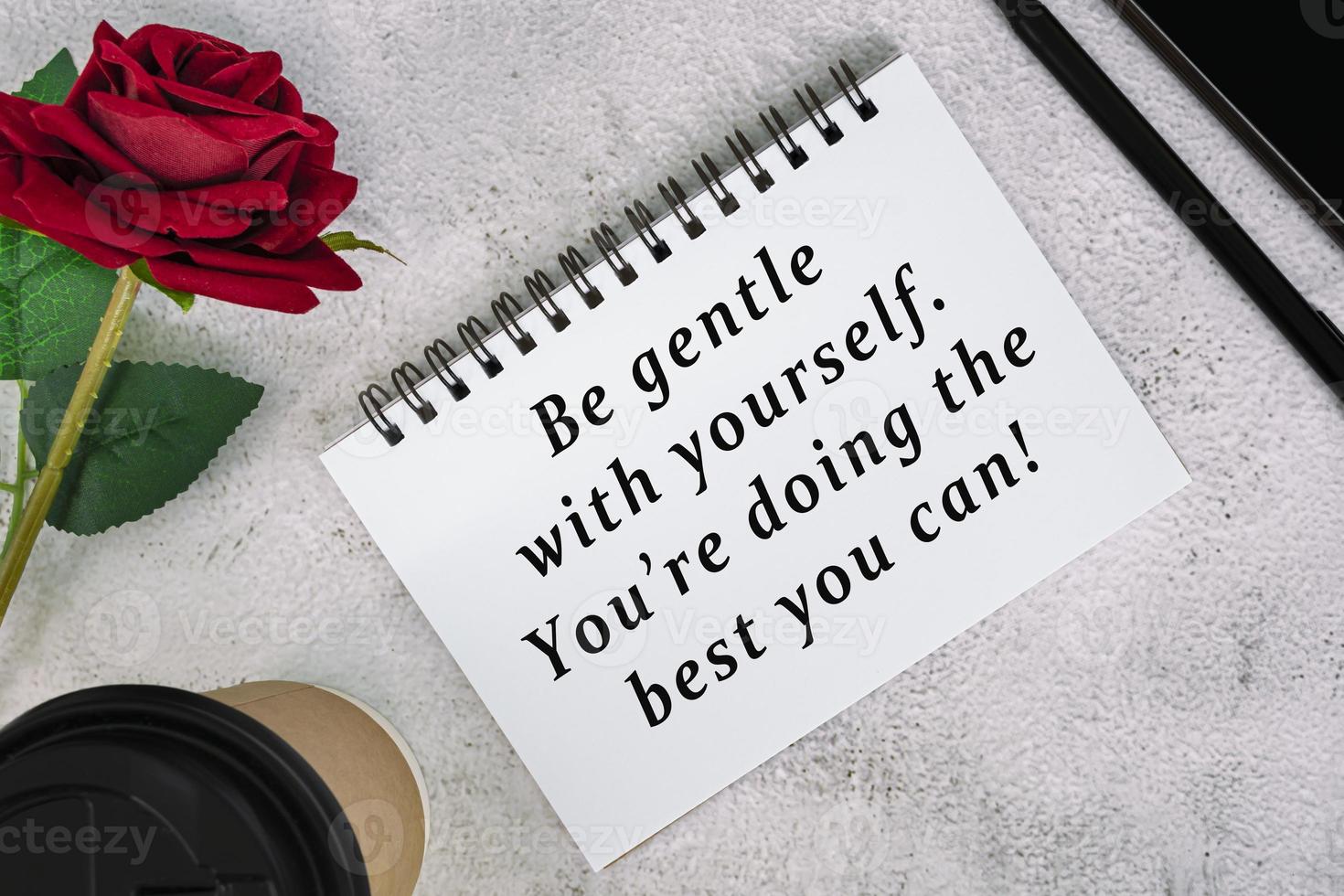 Motivational and inspirational quote on a note book on white marble table. photo