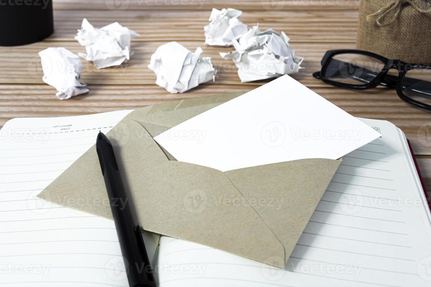 Notepad with trash paper background on wooden desk. Resignation concept. photo