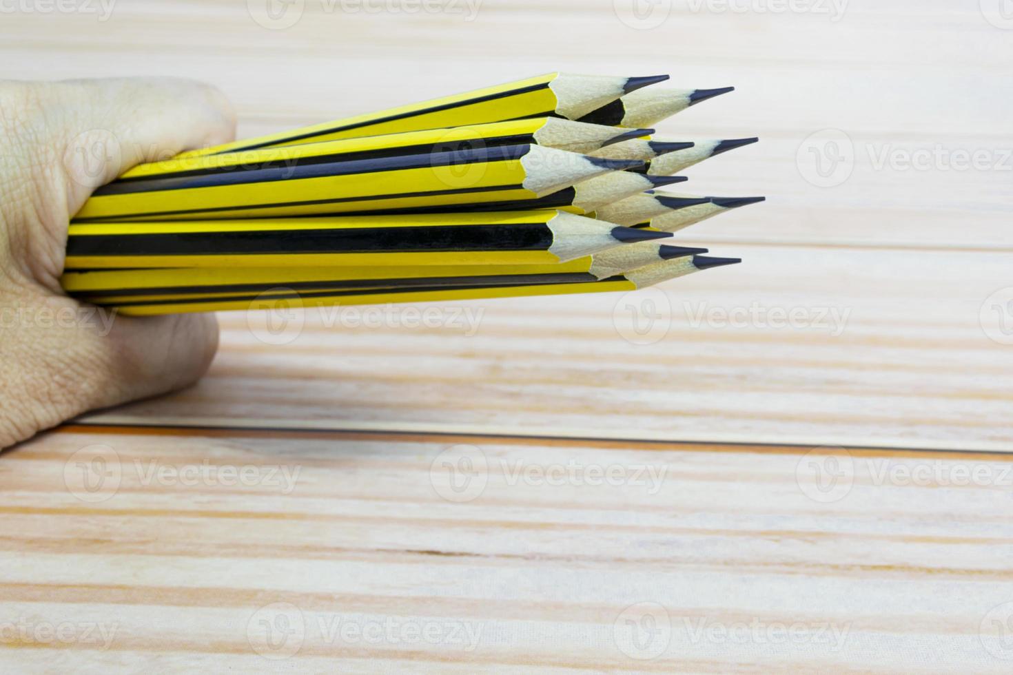 Wooden 2b pencils lying on red note book on wooden table. Copy space. photo
