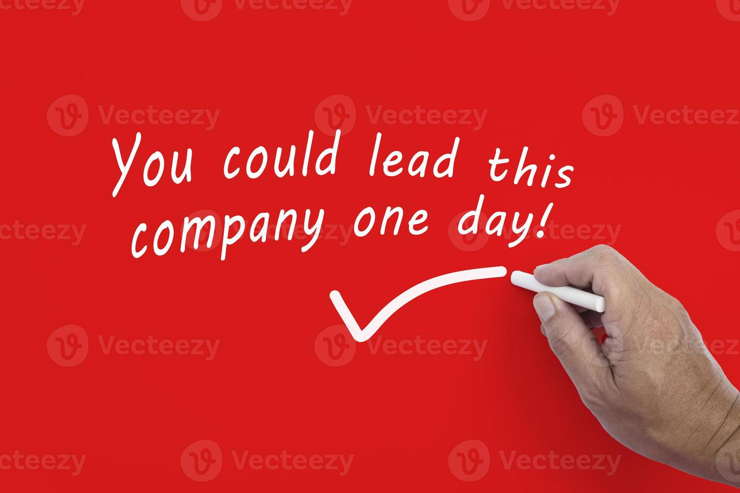 Hand writes in white chalk pencil the word YOU COULD LEAD THIS COMPANY ONE DAY. photo